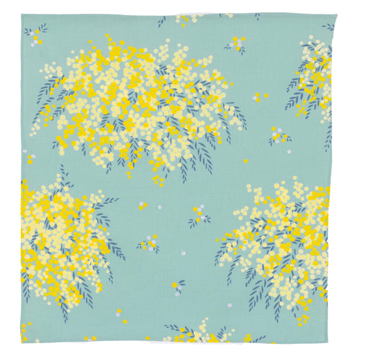 Flat lay view of a square Japanese furoshiki cloth featuring a bright yellow mimosa flower pattern printed on a mint green cotton background.
