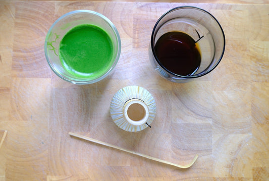 A side-by-side comparison of morning caffeine options: vibrant green matcha green tea next to dark black coffee, featuring traditional Japanese matcha preparation tools.