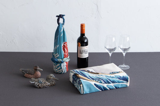 Furoshiki wrapped around a wine bottle tied, and another Furoshiki wrapped around a rectangular gift box