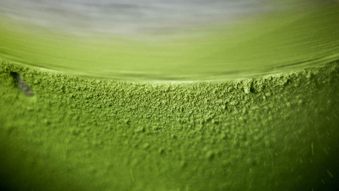 The rich, velvety texture of premium ceremonial matcha powder during the traditional stone-grinding process.