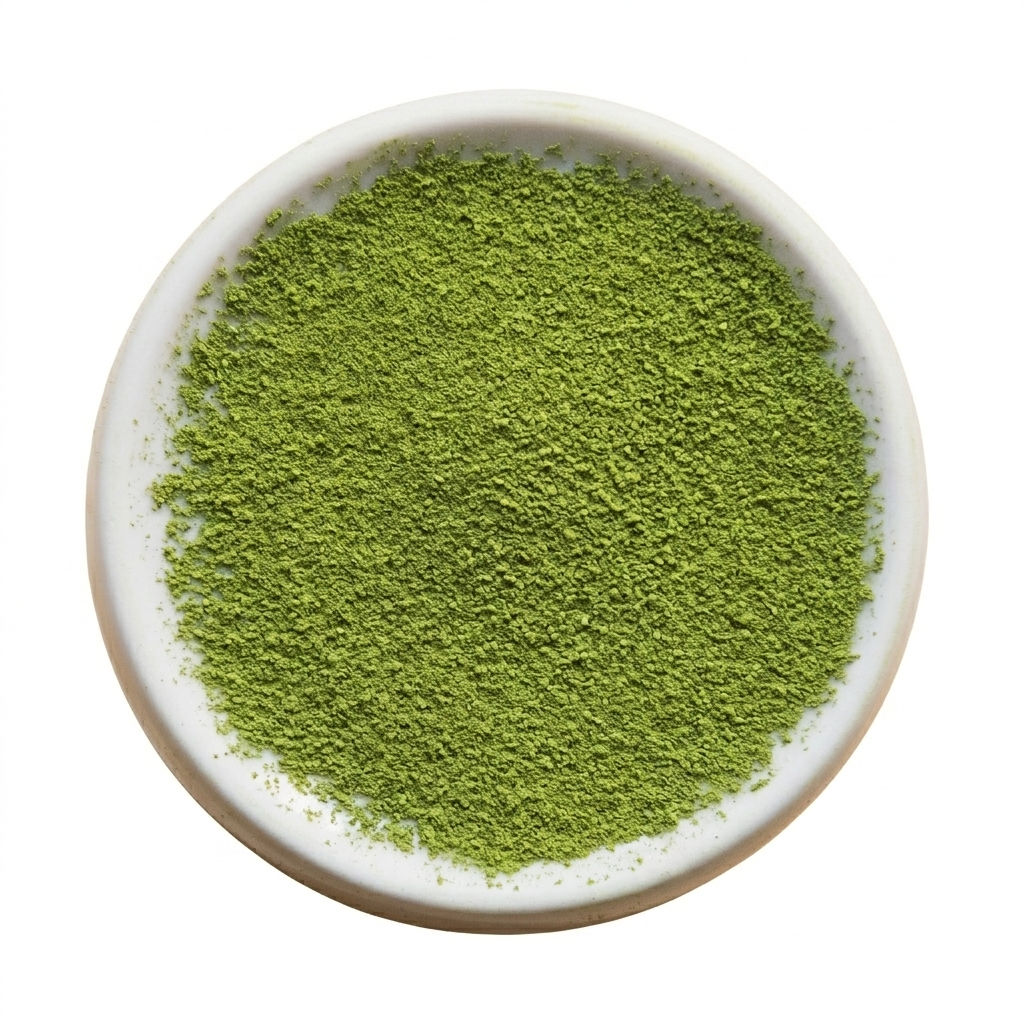 Green powder in a white bowl on a white background