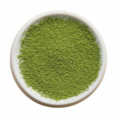 Green powder in a white bowl on a white background