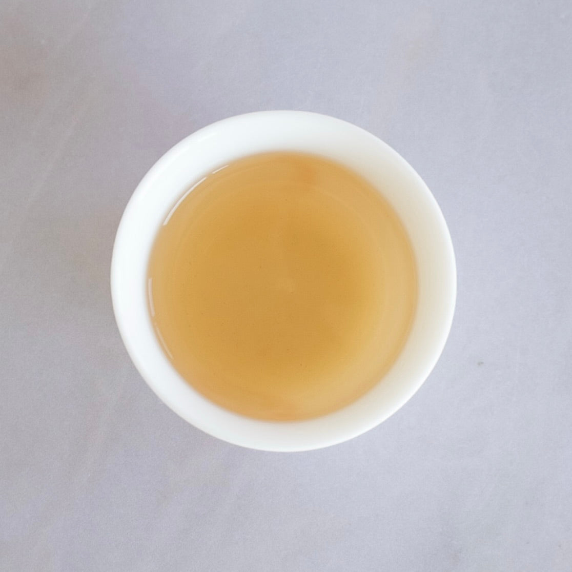 Steeped GABA high mountain oolong tea in a white tasting cup from Tea Studio Lu Switzerland