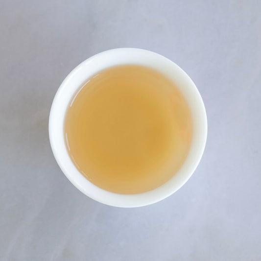 Clear infusion of Taiwanese GABA oolong tea served in a traditional white cup by Tea Studio Lu Switzerland